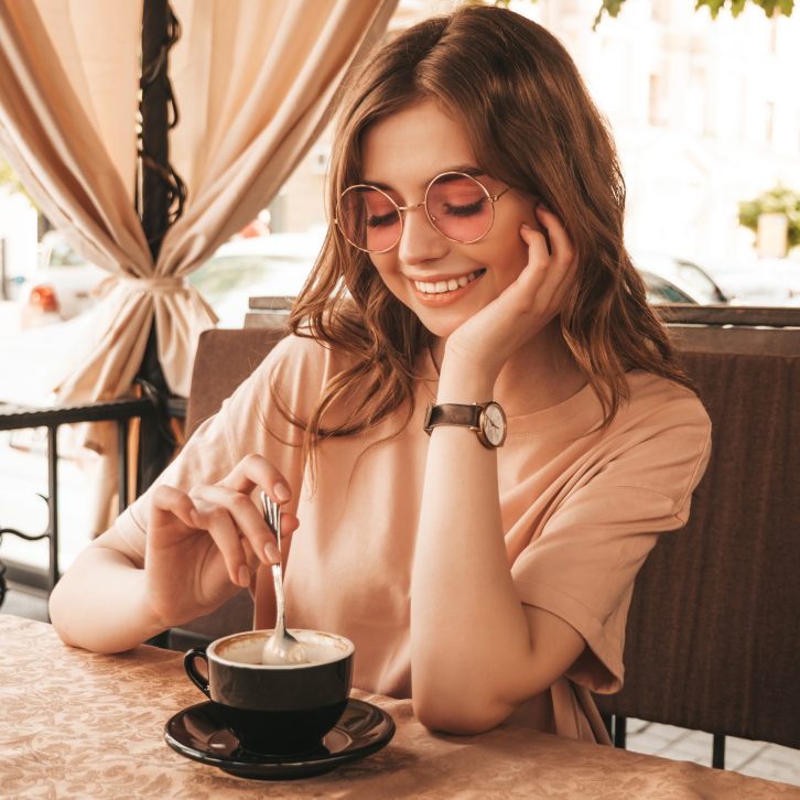 beautiful girl in a cafe preparing to drink cappuccino